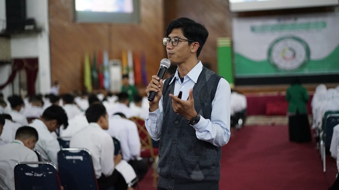 Photo by Herlambang Tinasih Gusti a man speaking into a microphone